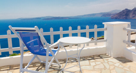 relaxing blue chair with table and view of volcano caldera, Santorini, Greeceの写真素材