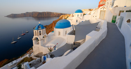 street of traditional greek village Oia of Santorini, with blue domes against Aegan sea and caldera, Greece, web banner formatの写真素材