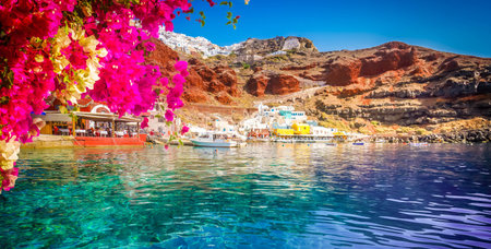 Amoudi bay, port of Oia, Santorini Greece at sunny summer with flowersの写真素材
