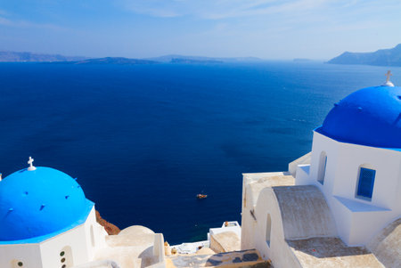 volcano caldera with classical blue church domes and Aegan blue sea, Oia, Santoriniの写真素材