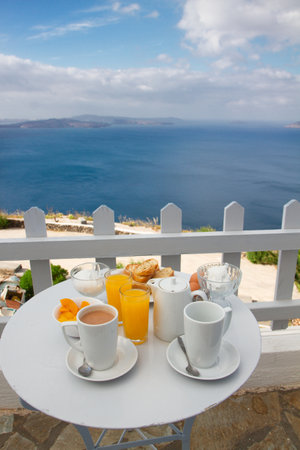 breakfast with coffee and fresh orange juice at morning by seasideの写真素材