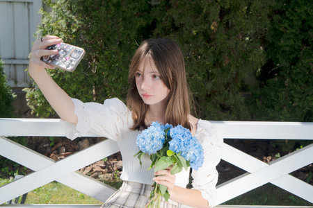 Teenager girl making selfie with flowers with her phone