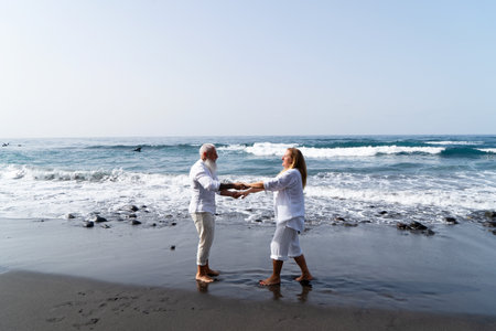 lifestyle of caucasian senior couple dance on beach, happy in love romantic and relax time, tourism of elderly family pleople, leisure and activity travel after retirement in vacations and summerの写真素材
