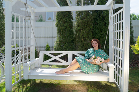 woman relaxing at garden swing at summerの写真素材
