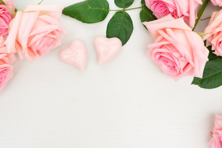 Rose fresh flower with two hearts and ribbon on table border from above with copy space, flat lay sceneの写真素材