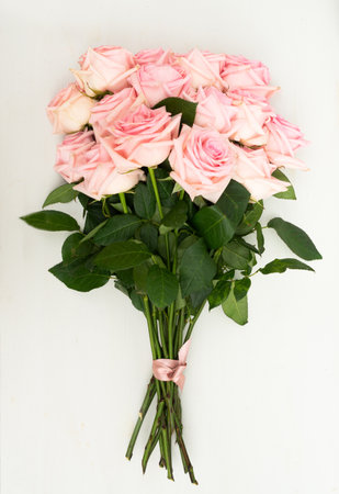 Rose fresh flowers bouquet on light table from above, flat lay sceneの写真素材