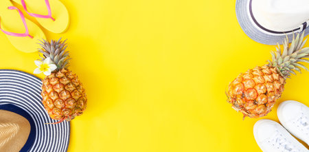 Summer flat lay scene with pair of hats and shoes on yellow background with copy spaceの写真素材
