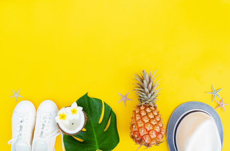 Summer flat lay border with green leaves, cocnut and shoes with copy spaceの写真素材