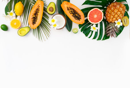 fresh exotic fruits with green tropical leves flat lay top view border, summer healthy diet backgroundの写真素材