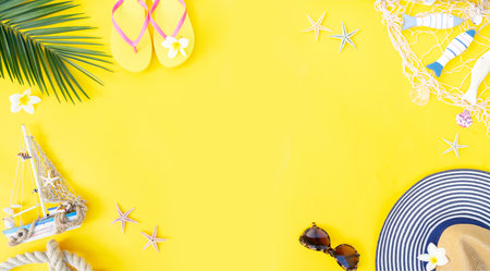 Summer flat lay frame with straw hat and green leaves on yellow background banner with copy spaceの写真素材