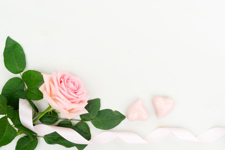 Rose fresh flower with two hearts and ribbon on table from above with copy space, flat lay top view sceneの写真素材