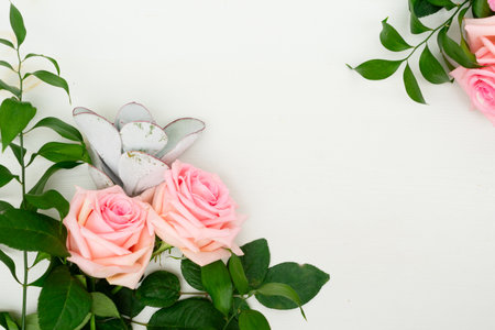 Rose fresh flowers with leaves on table from above with copy space, flat lay frameの写真素材