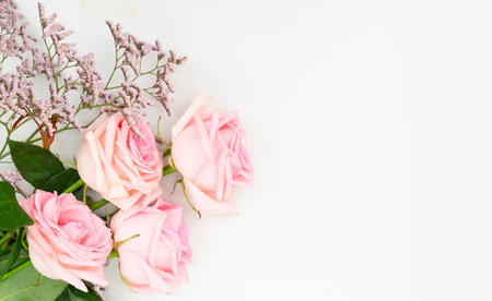 Rose fresh flowers with leaves frame on table from above with copy spaceの写真素材