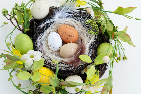 Easter scene with colored eggs in nest with flowersの写真素材