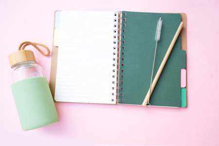 Zero waste concept, reusable eco-friendly straw and bottle for water over pink background with copy spaceの写真素材