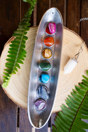 seven chakras stones over wooden background, energy healing conceptの写真素材
