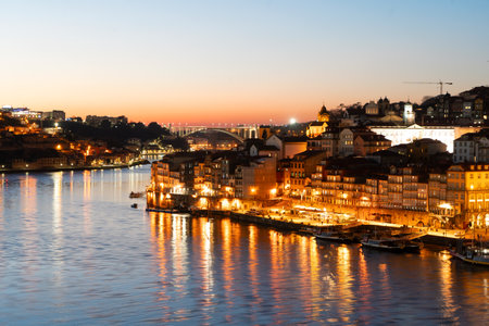 Picturesque, colorful view at old town Porto at night, Portugal with bridge Ponte Dom Luis over Douro river. Oporto, touristic mediterranean cityの写真素材