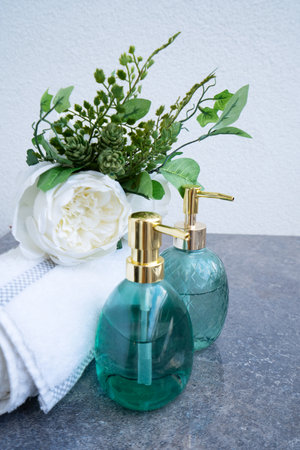 Still life with towel and cosmetics in green bottlesの写真素材