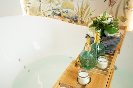 Bath water basin in white bathroom with relaxation cosmetics bottlesの写真素材