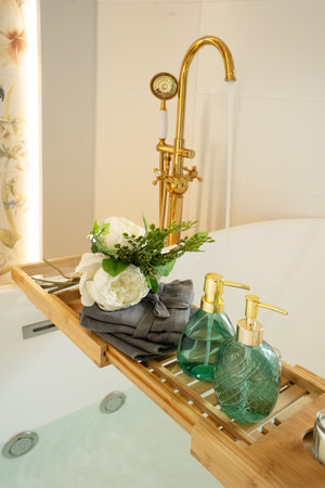 Bath water basin in white bathroom with relaxation cosmetics bottlesの写真素材