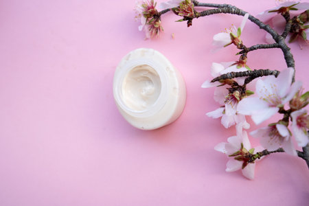 spring flowers with face cream over pink backgroundの写真素材