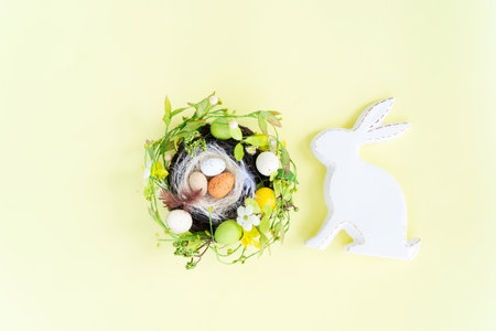 Easter scene with colored eggs in nest and handmade bunny, top view flat layの写真素材