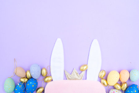 Easter scene with colored eggs and rabbits earsの写真素材