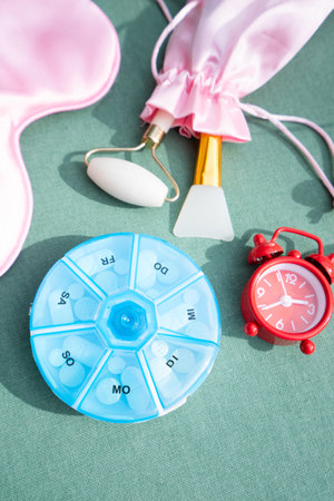 alarm clock with sleeping mask and pill box, sleep-wake disorders concept, insomnia therapy, sleep difficulties and deprivationの写真素材