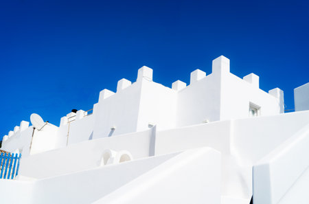 traditional greek village of Santorini, white walls against blue skyの写真素材