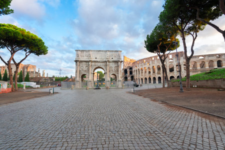 Arch of Constantine and Colosseum with empty alley road, antique Rome city, Italyの写真素材
