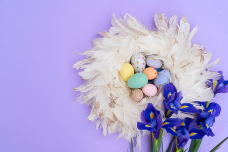 Easter scene with colored eggs in nest over violet backgroundの写真素材