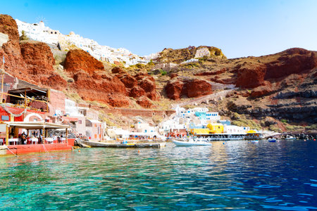 Amoudi bay with brilliant water and boats, port of Oia, Santorini Greece at sunny summerの写真素材