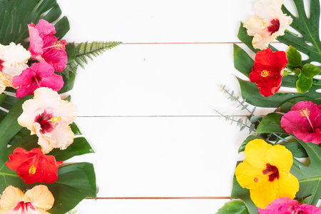Tropical flowers and leaves on wooden background, summer vacational backgroundの写真素材
