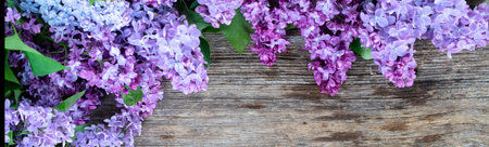 Fresh lilac flowers over wooden background with copy space, flat lay floral composition with copy spaceの写真素材