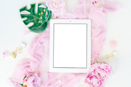 Creative wedding composition with tablet frame mock up, pink blanket, flowers on white background. Flat lay, top view stylish art concept.の写真素材