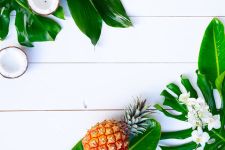 Summer flat lay scenery with tropical leaves and friuts on white background with copy spaceの写真素材