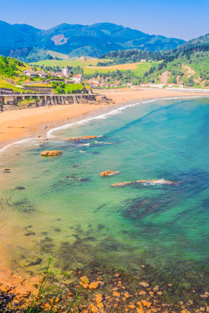 Cantabrian Sea green coast with Deba town at summer day, Pais Vasco Spain