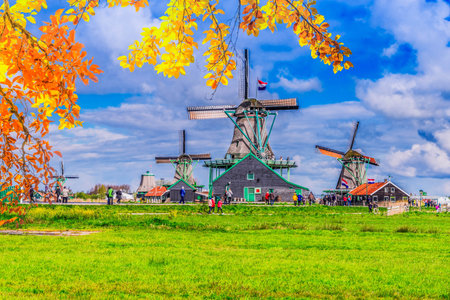 traditional Dutch scenery with windmill of Zaanse Schans with dramatic cloud sky, Netherlands at fallの写真素材