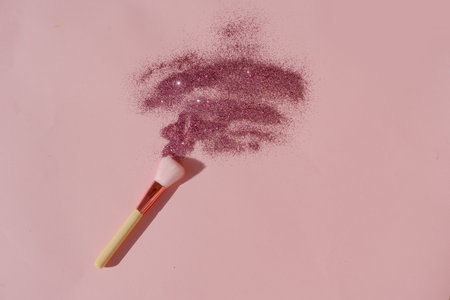 Minimal modern cosmetic scene with set of make up brushes set over pink background with glitter and...