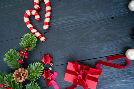 Colorful Christmas decorations with candy canes, shiny ornaments, and a beautifully wrapped gift in red ribbonの写真素材