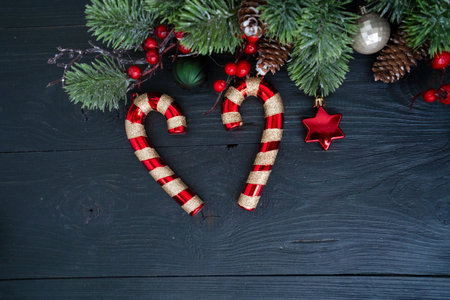 Colorful Christmas decorations with candy canes, shiny ornaments, and a beautifully wrapped gift in red ribbonの写真素材