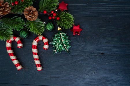 Colorful Christmas decorations with candy canes, shiny ornaments, and a beautifully wrapped gift in red ribbonの写真素材