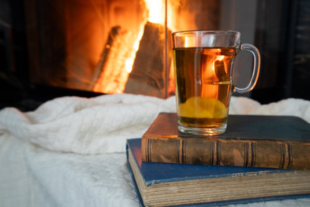Imagine a cozy scene with beloved books, soothing tea, and a crackling fireplace for ultimate relaxationの写真素材