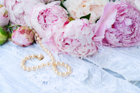 Fresh peonies flowers over lace background, close up view, summer backgroundの写真素材