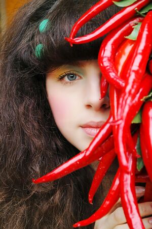 woman's portrait with red peppersの写真素材