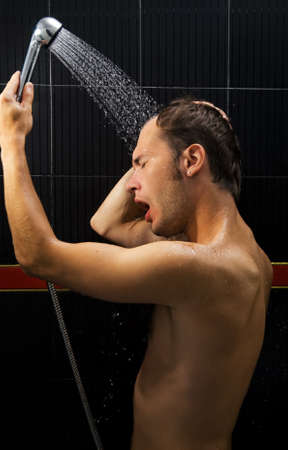 Young handsome man in a showerの写真素材