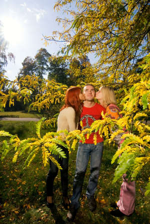 Two girs kissing one guyの写真素材