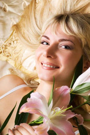 Happy young woman with pink lilyの写真素材