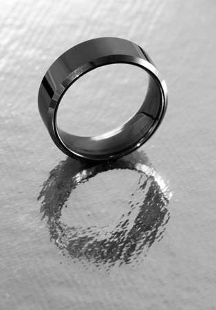 Silver ring reflected in silver surfaceの写真素材