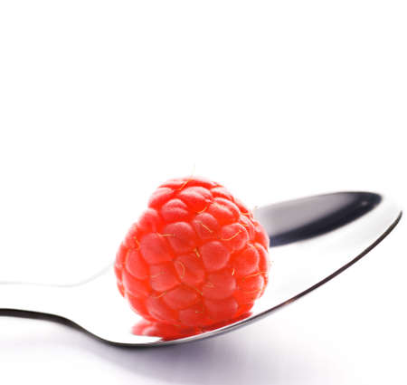 Ripe raspberry in silver spoon isolated on white backgroundの写真素材